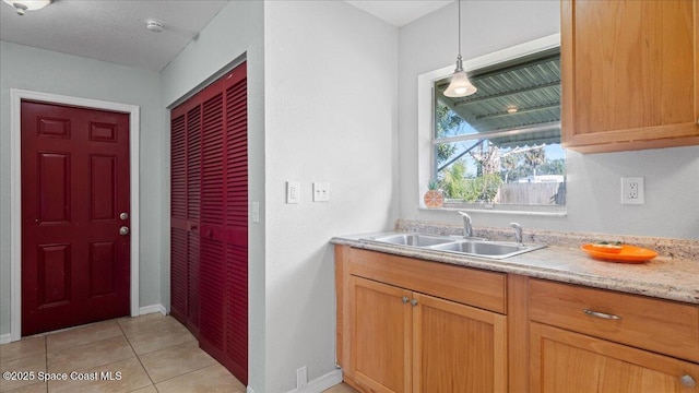 kitchen featuring pendant lighting, sink, and light tile patterned floors