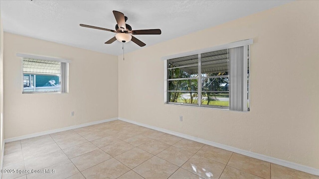 tiled empty room featuring a textured ceiling and ceiling fan