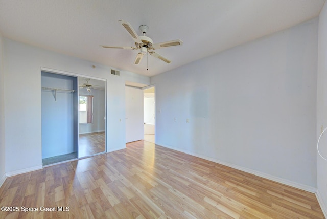 unfurnished bedroom featuring light hardwood / wood-style flooring, a closet, and ceiling fan