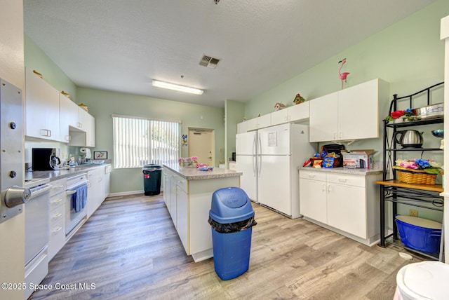 kitchen featuring white cabinetry, a kitchen island, white appliances, and light hardwood / wood-style flooring