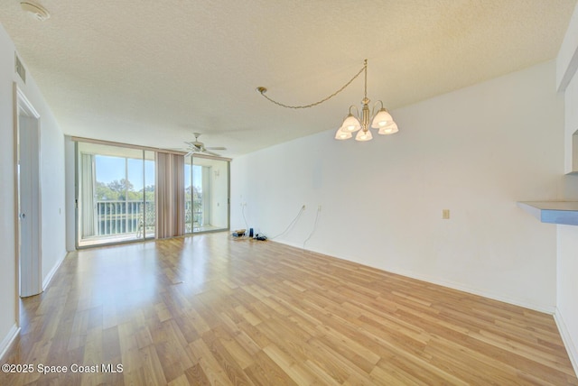 interior space with floor to ceiling windows, a textured ceiling, and light wood-type flooring