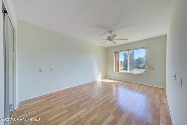 spare room featuring ceiling fan, a textured ceiling, and light wood-type flooring