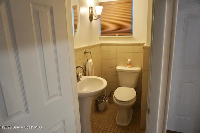 bathroom with tile patterned flooring, tile walls, and toilet