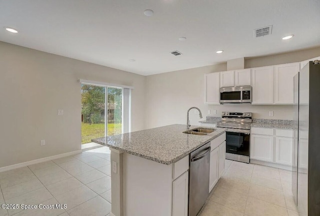 kitchen with sink, a kitchen island with sink, white cabinetry, stainless steel appliances, and light stone counters