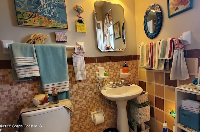 bathroom featuring tile walls and toilet