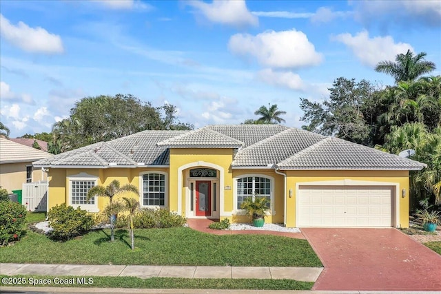 mediterranean / spanish-style home with a garage and a front yard