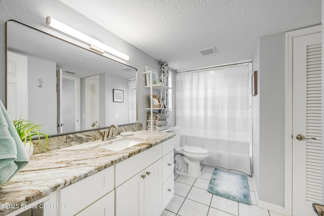 bathroom featuring vanity, tile patterned flooring, toilet, and a textured ceiling