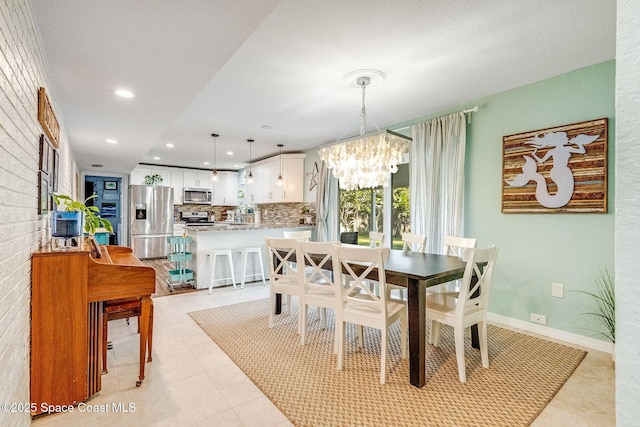 dining space featuring sink, light tile patterned floors, and an inviting chandelier