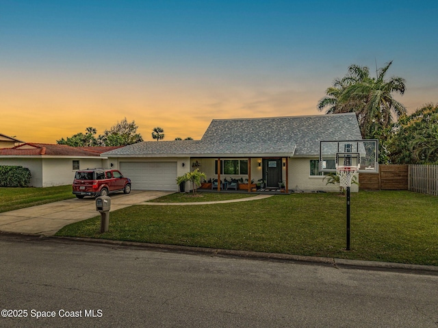 ranch-style house with a garage and a yard