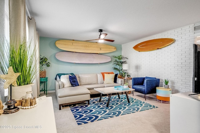 tiled living room featuring ceiling fan and brick wall