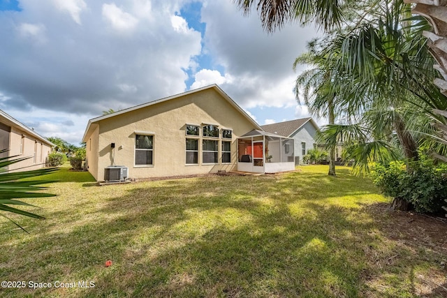 back of property featuring a yard, a sunroom, and central air condition unit