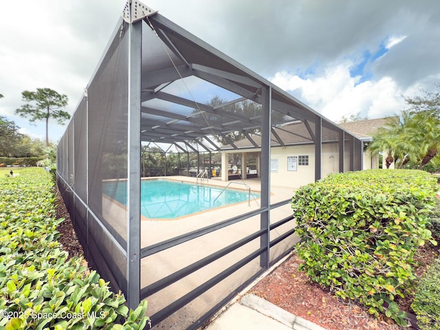 view of pool featuring a patio and glass enclosure