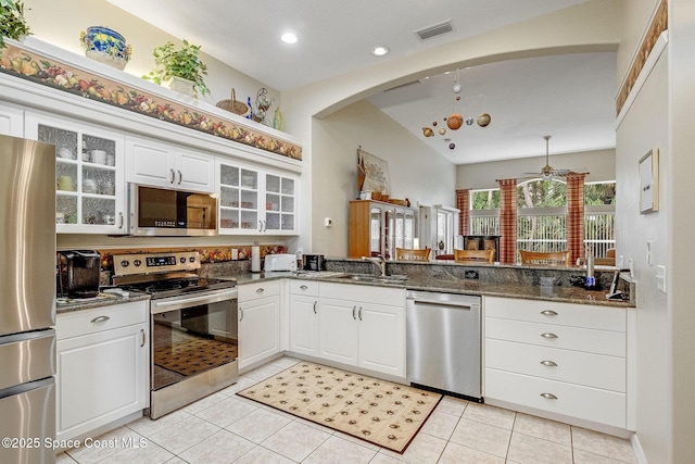 kitchen with white cabinetry, appliances with stainless steel finishes, dark stone countertops, and light tile patterned floors