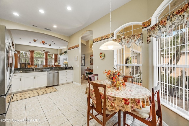 kitchen with white cabinetry, hanging light fixtures, stainless steel appliances, and light tile patterned flooring