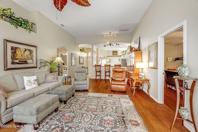 living room with lofted ceiling, light hardwood / wood-style floors, and ceiling fan