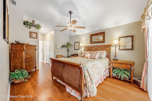 bedroom with vaulted ceiling, a closet, ceiling fan, and light hardwood / wood-style flooring