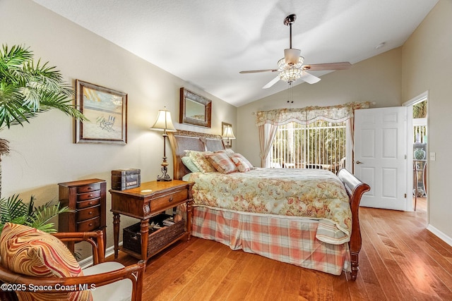 bedroom featuring hardwood / wood-style flooring, lofted ceiling, access to exterior, and ceiling fan