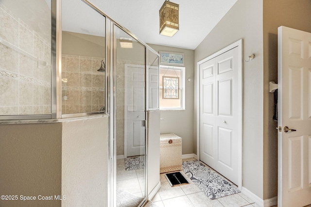 bathroom with tile patterned flooring and a shower with door