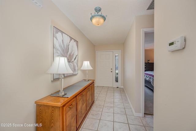 tiled entryway with a textured ceiling