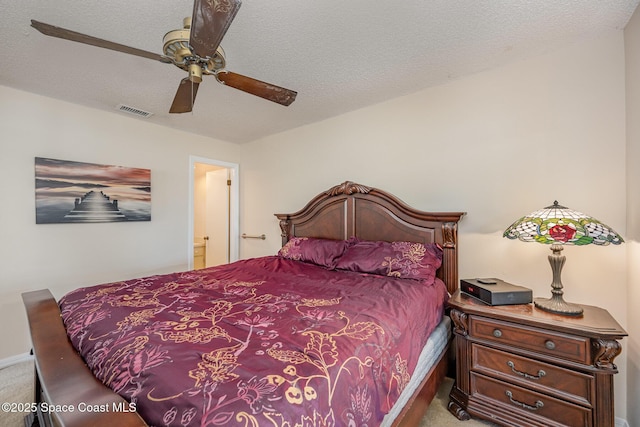 carpeted bedroom with ceiling fan and a textured ceiling