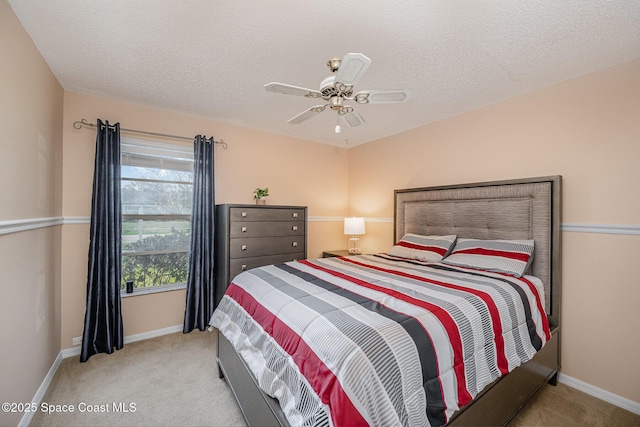 bedroom featuring ceiling fan, light carpet, and a textured ceiling