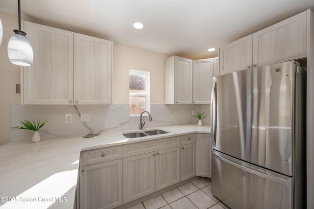 kitchen featuring light tile patterned flooring, sink, stainless steel fridge, pendant lighting, and backsplash