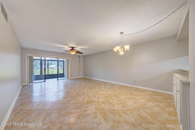 empty room with light tile patterned flooring, ceiling fan with notable chandelier, and a textured ceiling