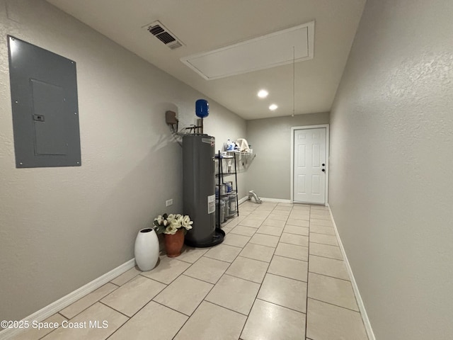 interior space featuring electric panel, water heater, and light tile patterned floors