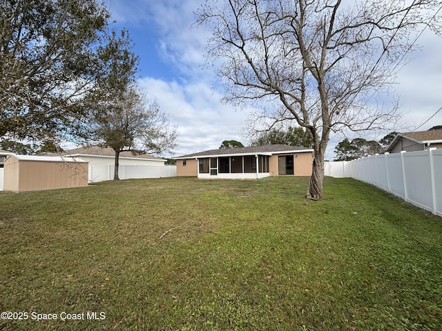 rear view of house featuring a lawn and a sunroom