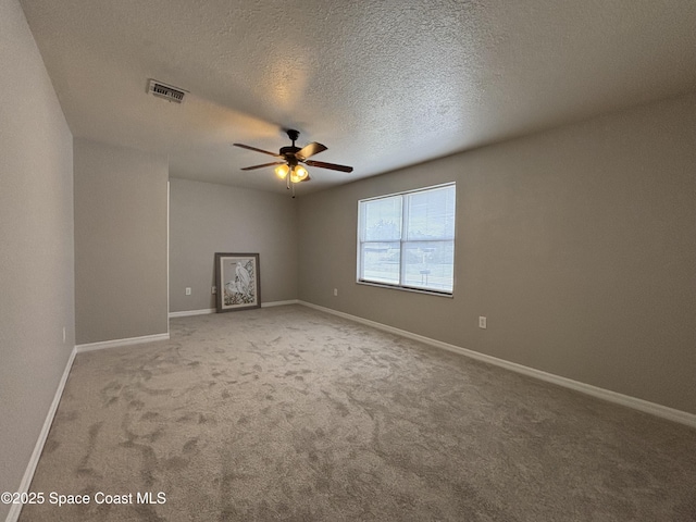 carpeted empty room featuring ceiling fan and a textured ceiling