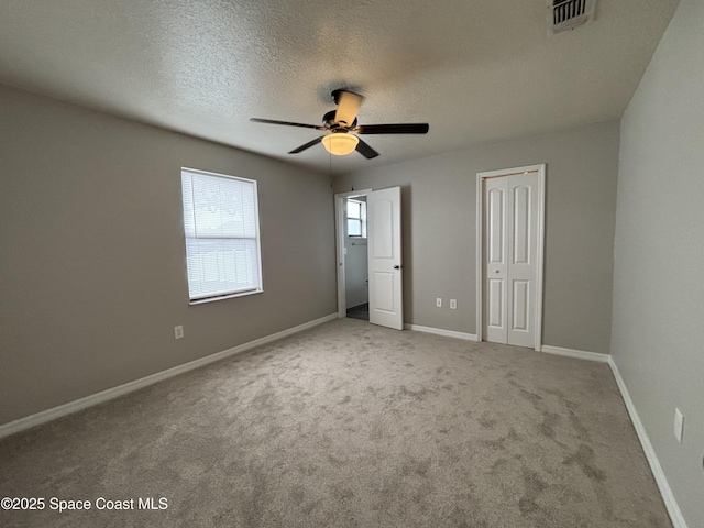 unfurnished bedroom with ceiling fan, carpet floors, and a textured ceiling