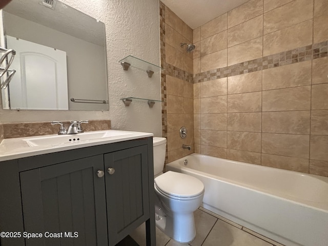 full bathroom with tiled shower / bath, vanity, toilet, tile patterned floors, and a textured ceiling