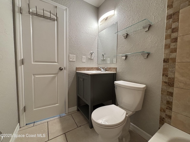 bathroom with vanity, a bathing tub, tile patterned floors, and toilet