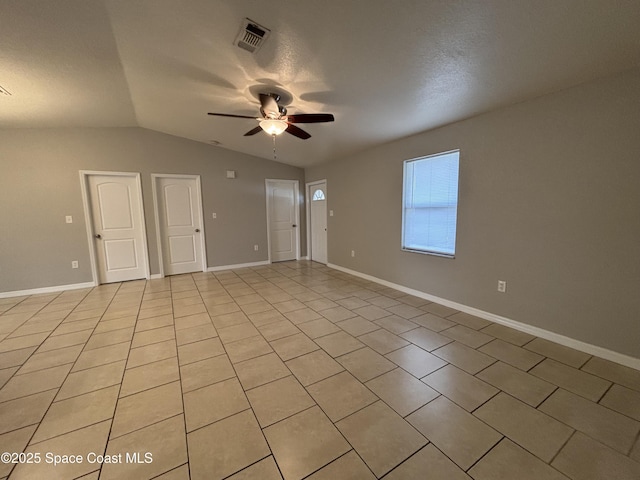 spare room with lofted ceiling, light tile patterned floors, and ceiling fan