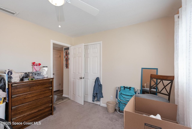 carpeted bedroom featuring a closet and ceiling fan