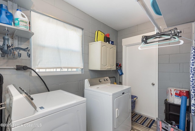 washroom with separate washer and dryer and cabinets