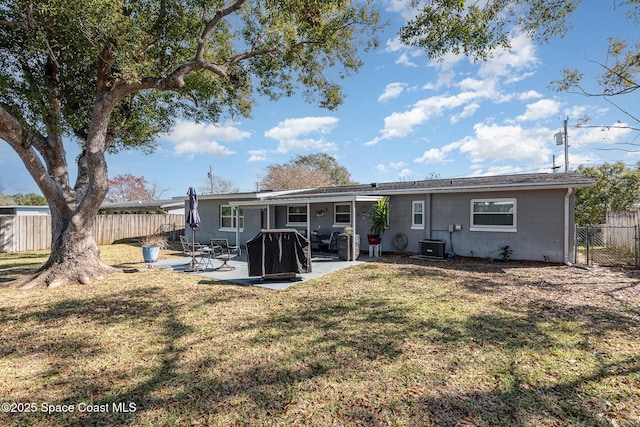 rear view of property with central AC unit, a yard, and a patio