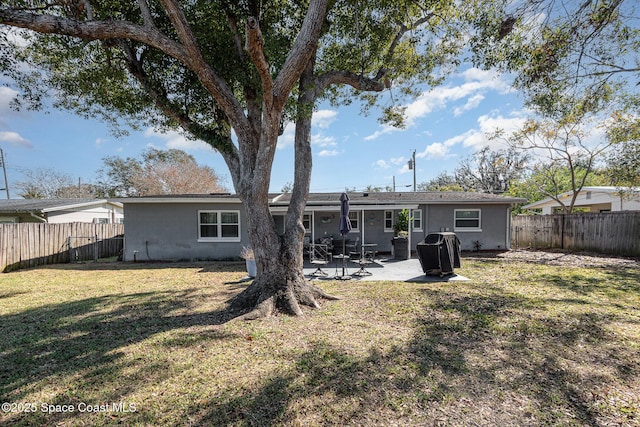 rear view of property with a yard and a patio area