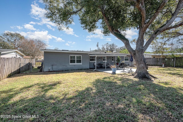 rear view of property with a patio and a lawn