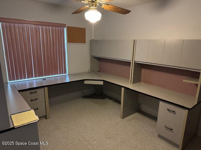 unfurnished office with built in desk and ceiling fan