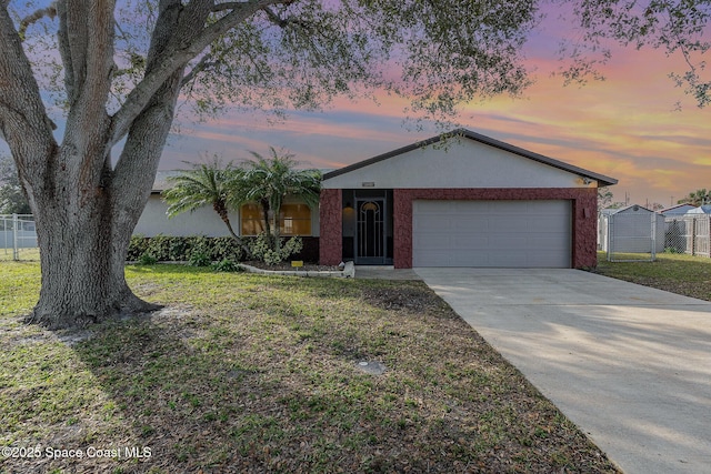 ranch-style house featuring a garage and a yard