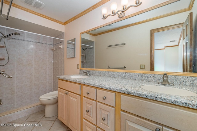 bathroom with vanity, tiled shower, toilet, crown molding, and tile patterned floors