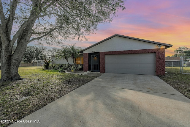 ranch-style home with a garage and a lawn