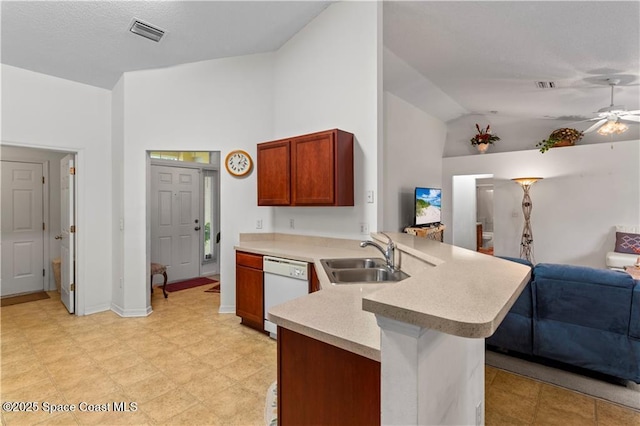 kitchen featuring vaulted ceiling, sink, white dishwasher, and kitchen peninsula