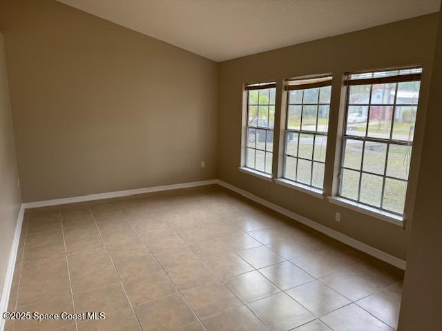 tiled empty room with a wealth of natural light