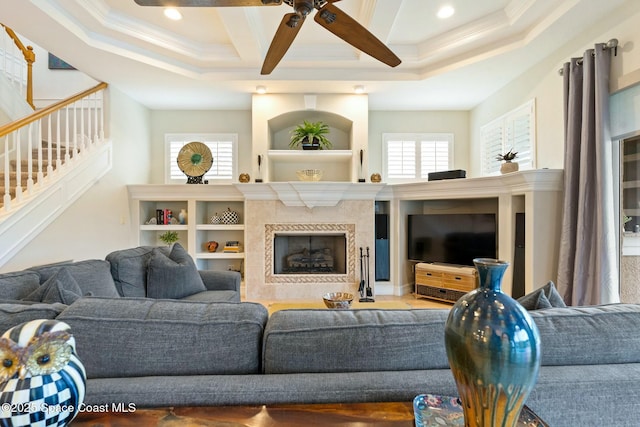 1459 Southpointe Ct, Melbourne, FL 32940 - living room with coffered ceiling, stairs, a tiled fireplace, a ceiling fan, and ornamental molding