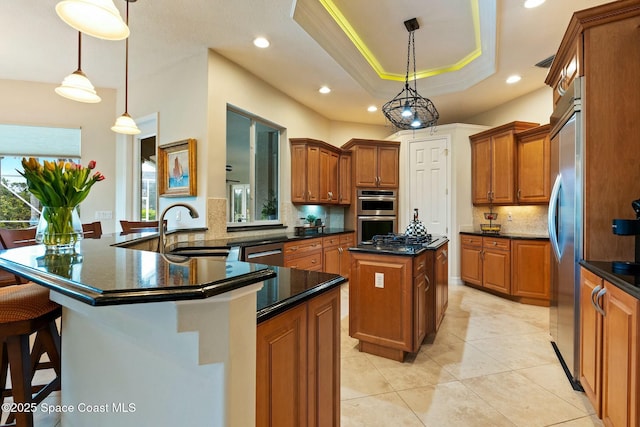 1459 Southpointe Ct, Melbourne, FL 32940 - kitchen featuring a sink, a raised ceiling, appliances with stainless steel finishes, a center island, and brown cabinets