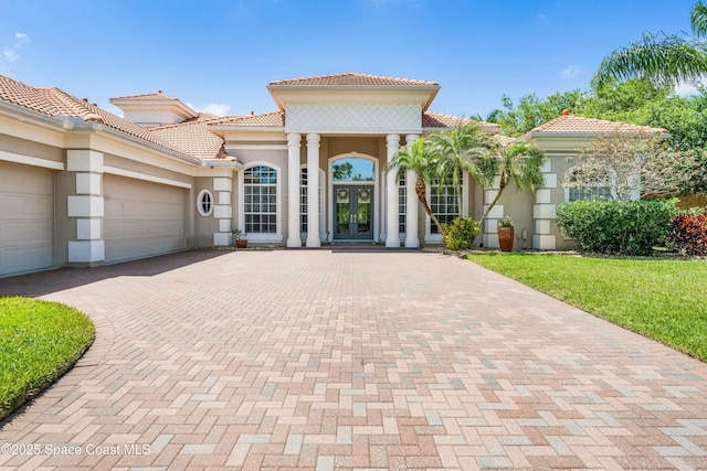 1459 Southpointe Ct, Melbourne, FL 32940 - mediterranean / spanish-style house with decorative driveway, a tile roof, stucco siding, and french doors
