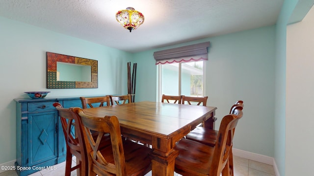 dining room featuring a textured ceiling and light tile patterned flooring