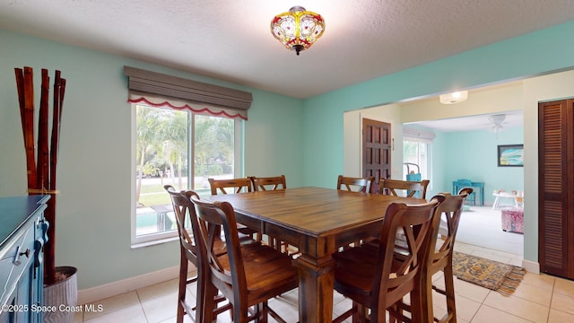 dining space with light tile patterned flooring and a textured ceiling